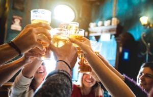 Group of happy friends drinking and toasting beer at brewery bar restaurant - Friendship concept with young people having fun together at cool vintage pub - Focus on middle pint glass - High iso image 1 AdobeStock 204371159