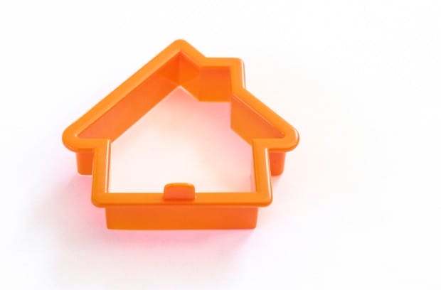 An orange house-shaped cookie-cutter that stands out against a white backdrop. It's a visual representation of repetitive design.